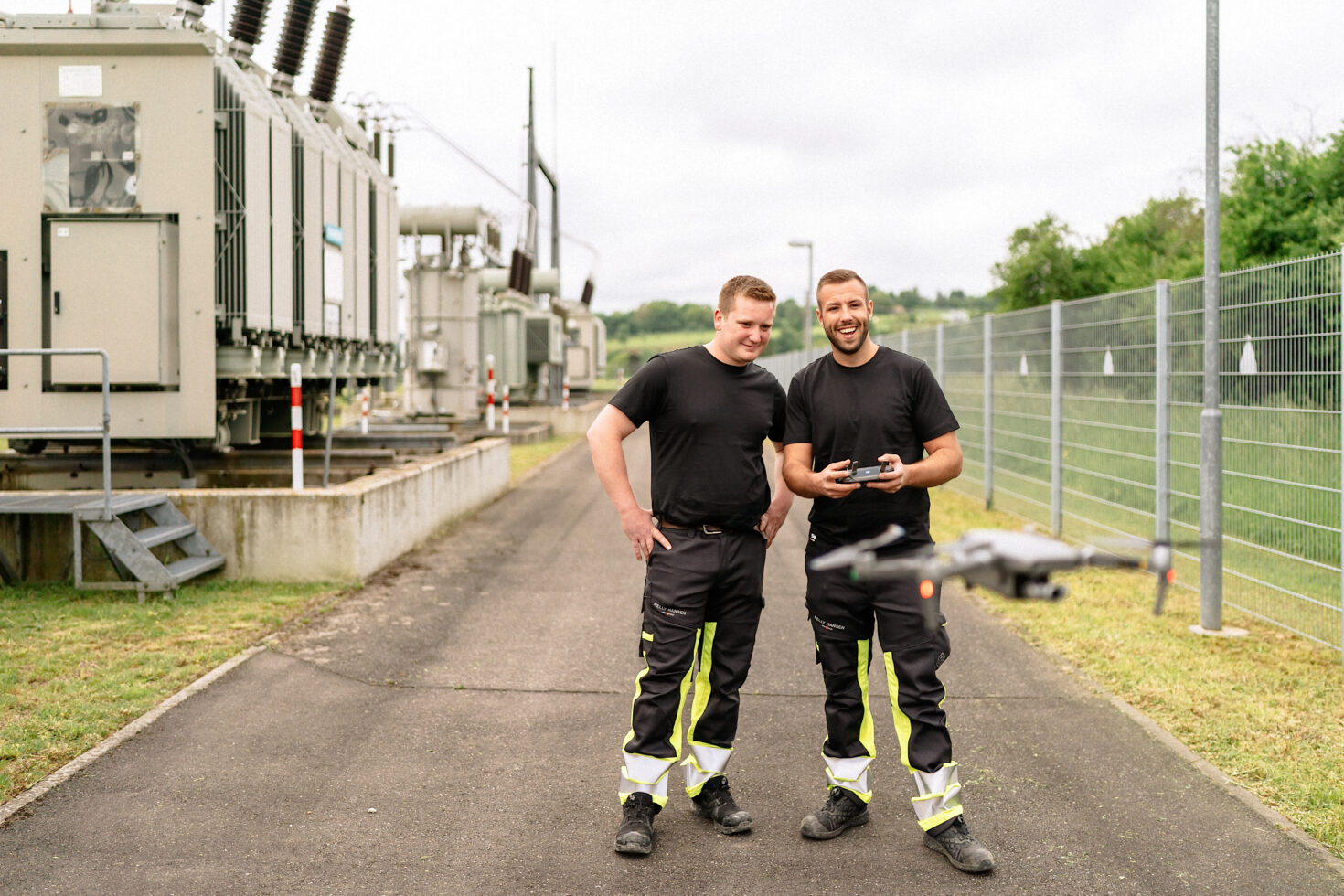 Zwei Mitarbeitende mit fliegender Drohne