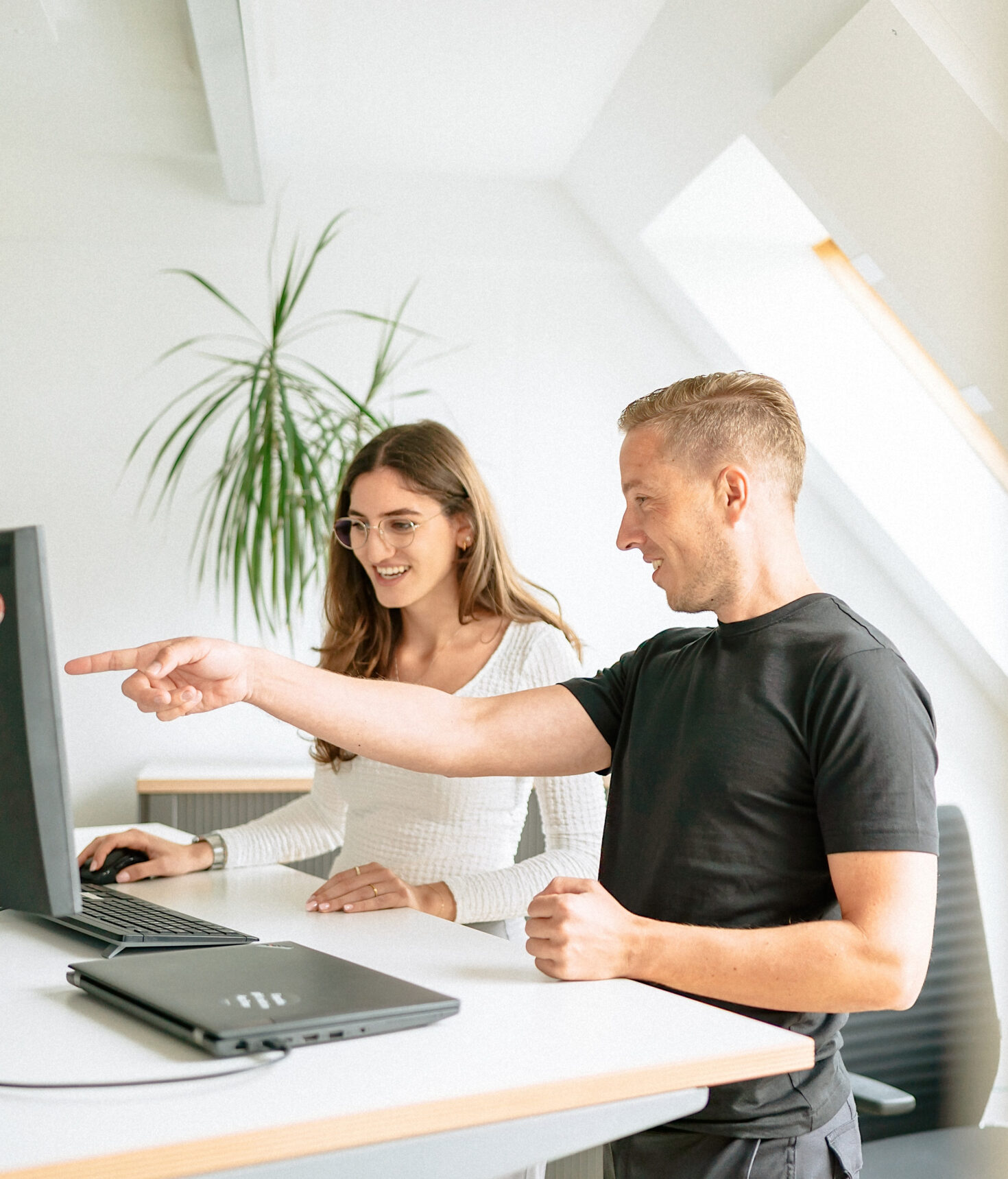 Zwei Mitarbeitende im Büro vor Computer